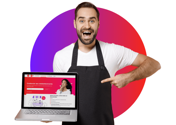 homem sorridente usando avental preto e camiseta branca, apontando para um laptop que exibe uma página na tela. Ao fundo, um círculo em gradiente de roxo para vermelho.