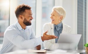 homem jovem e mulher idosa em reunião praticando como dar feedback de forma construtiva