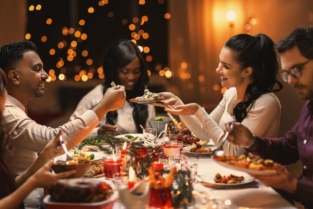 Um grupo de pessoas sentadas em volta de um presente de natal