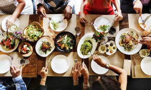 mesa com diversas pessoas participando de um almoço saudável