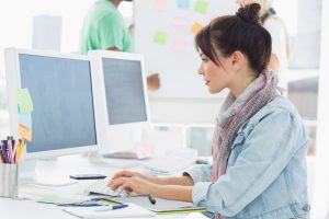 Mulher sentada usando o computador definindo o valor para o vale-refeição em 2024