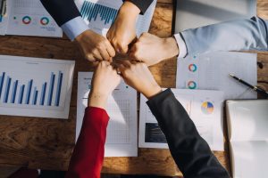 Cinco punhos unidos mostrando como valor para o vale-refeição em 2024 é motivador