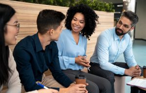 Quatro colaboradores engajados conversam animadamente sentados