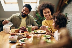 família com três pessoas compartilham uma refeição saudável