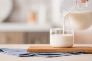 leite sendo servido em um copo transparente