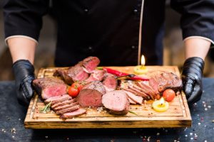 tábua com diversos tipos de carne vermelha sendo servido