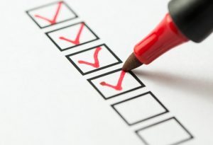 checklist sendo preenchido com caneta vermelha