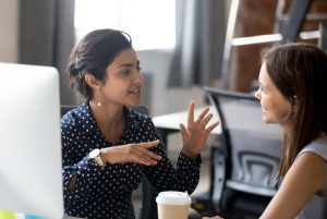 gestora de RH conversa e gesticula com funcionária