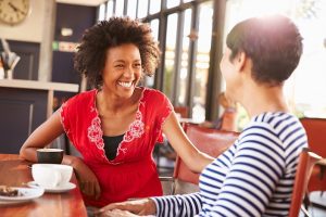 mulheres sorrindo e conversando em um café