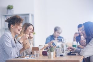 grupo de mulher comendo sentadas em  mesa de restaurante