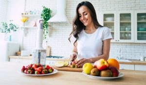 mulher corta legumes enquanto cozinha