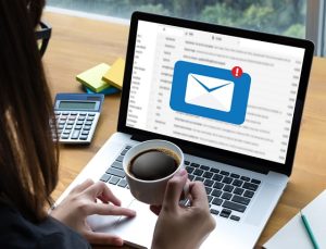 mulher usando um e-mail e tomando um café