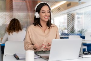 Mulher sentada em frente ao laptop com fone de ouvido