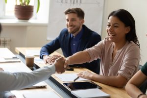 mulher-apertando-as-maos-em-uma-reuniao-corporativa