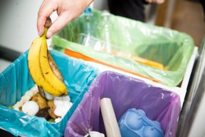 pessoa-segura-banana-em-cima-de-ponto-de-descarte-de-lixo-organico