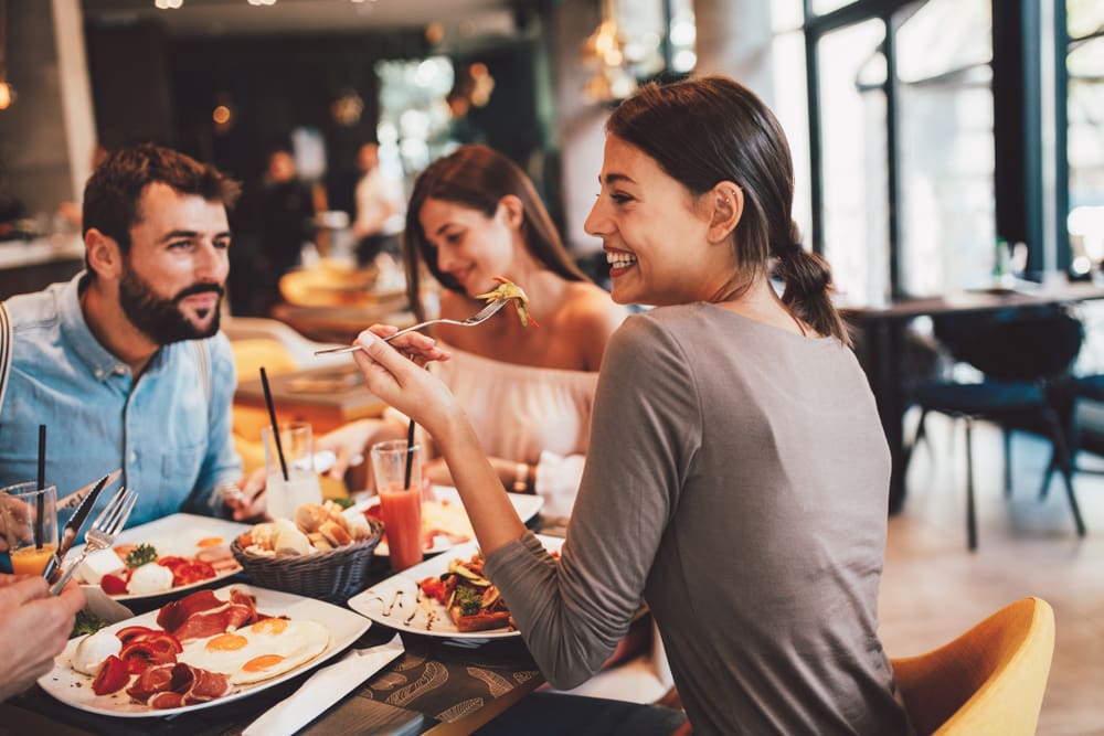 grupo de amigos sorrindo almoçando juntos