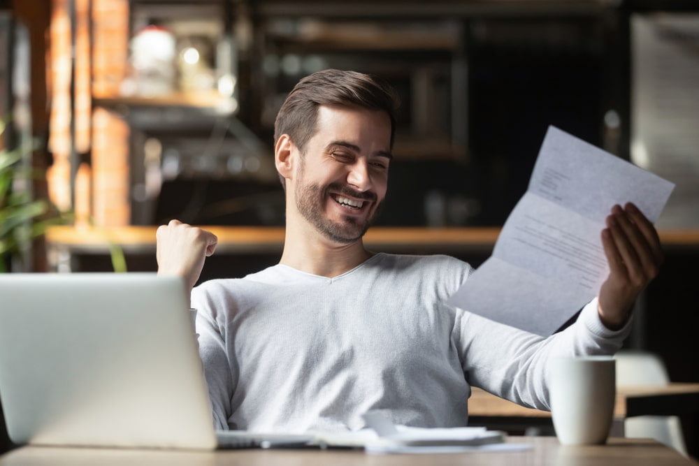 homem animado lendo carta de concessão do seu auxílio doença