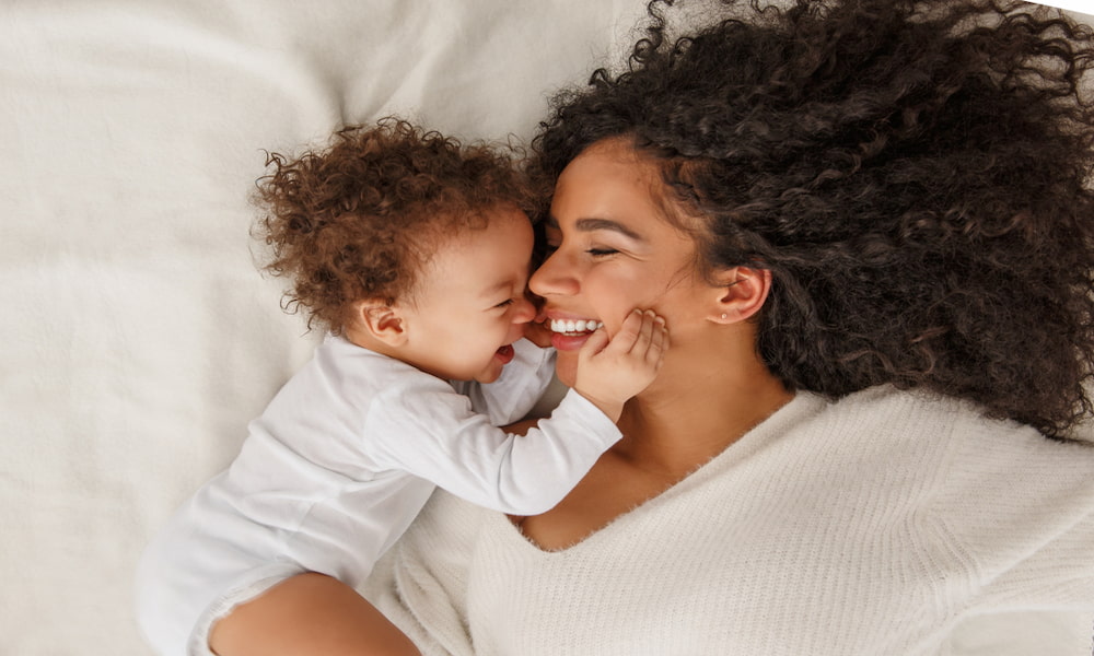 mãe e bebê deitados na cama