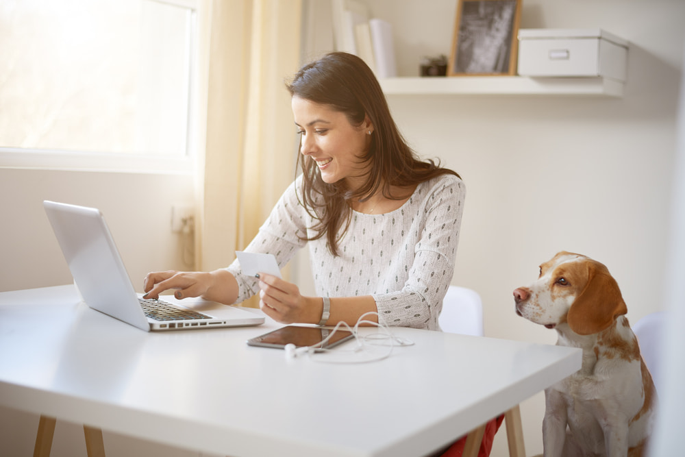 mulher trabalhando no home office ao lado do seu cachorro