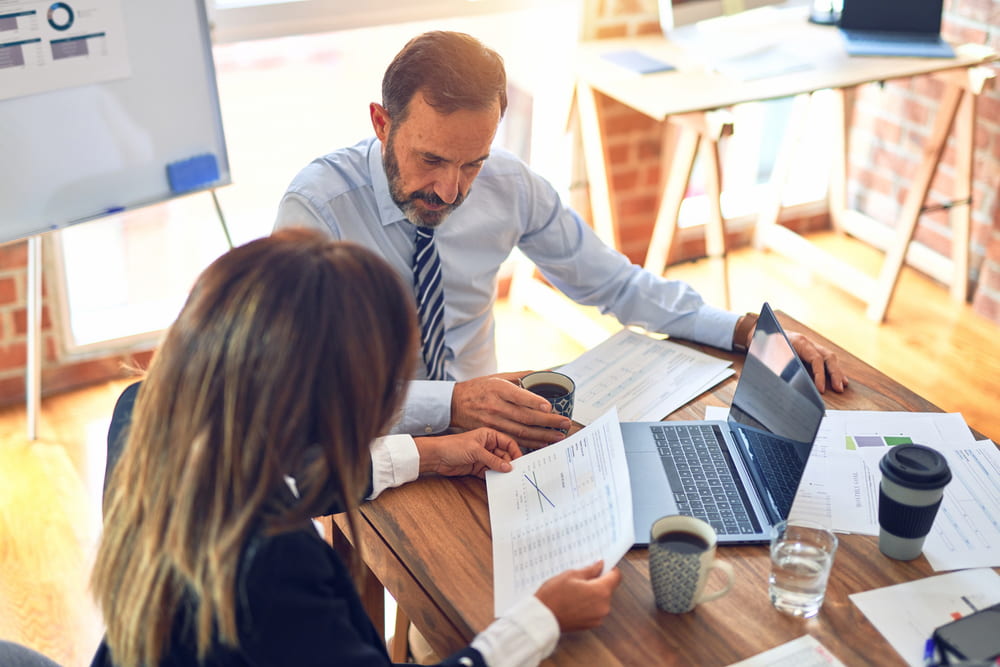 Grupo de executivos analisando métricas para um recrutamento eficaz