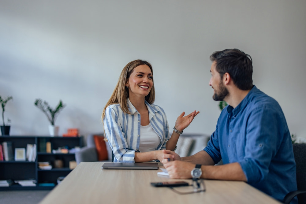 Recrutadora interna conversando com um funcionário conhecido para avaliar uma promoção interna