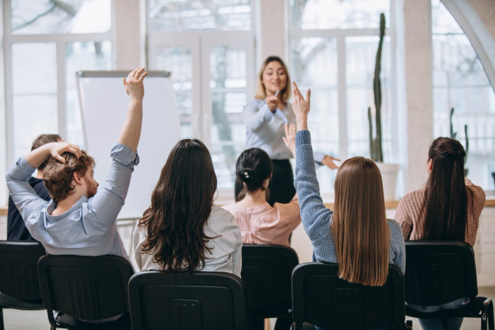 grupo de colaboradores tiram dúvidas com a professora em sala de aula de educação continuada.