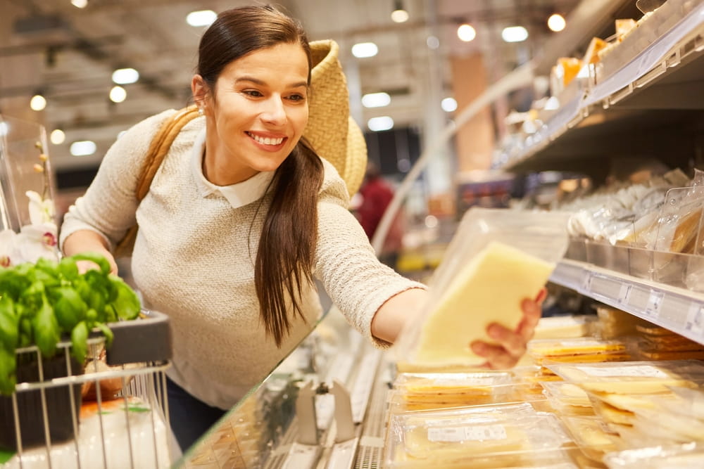 mulher comprando queijo no supermercado
