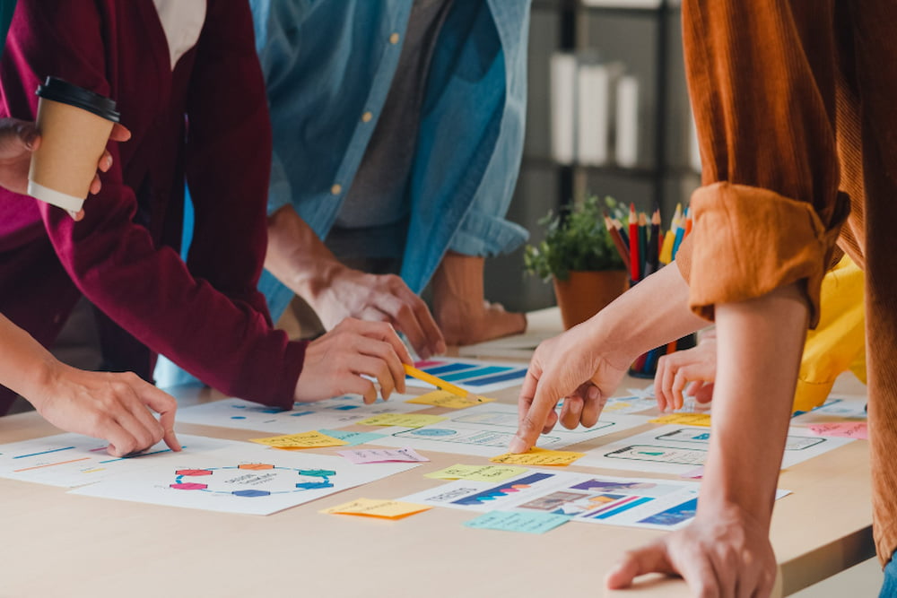 time de colaboradores trabalhando em um organograma funcional em uma mesa de reuniões.
