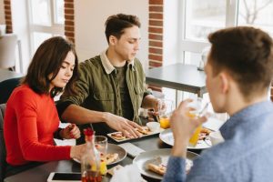 Colegas de trabalho almoçam em restaurante usando vale-refeição como meio de pagamento