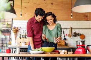 Casal cozinha alimentos comprados com vale-alimentação