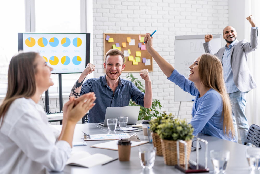 jovens trabalhadores celebrando em reunião