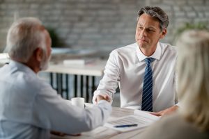 dois homens e uma mulher em mesa de negócios conversam sobre captação de recursos financeiros