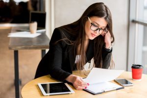 mulher sentada à mesa pratica como calcular o desconto do vale-alimentação