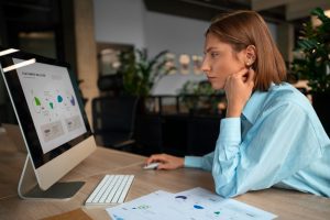 mulher sentada estudando no computador sobre como implementar o registro de ponto