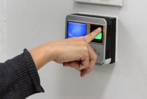 mulher fazendo o seu registro de ponto colocando a digital no sensor biométrico