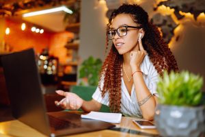 Colaboradora sentada à mesa de trabalho fazendo seu pedido de férias