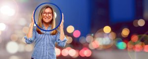 Mulher em fundo colorido e desfocado segura um círculo azul em volta da sua cabeça simbolizando que um dos pilares da aprendizagem personalizada é o foco no individuo