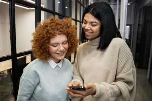 Duas mulheres jovens estão sorridentes enquanto veem as vantagens de usar o Ticket Super Flex