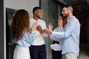 Quatro pessoas em pé conversando amigavelmente no trabalho, após receberem treinamento em neuroliderança