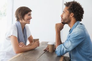 Homem e mulher se olham amigavelmente num processo de mentoria