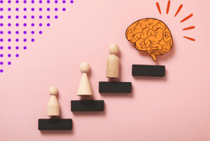 figura simboliza escada de madeira com 4 degraus. Em 3 deles, peões de madeira. No quarto, mais elevado, o desenho de um cérebro simbolizando a neuroliderança 