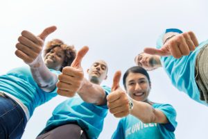 4 pessoas com camiseta azul fazem sinal de positivo para o Novembro Azul