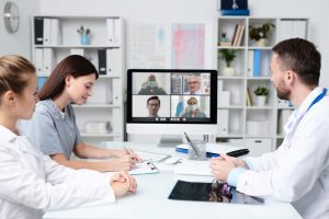 Equipe faz videoconferência em sala de reunião, mostrando a importância da tecnologia no rh