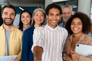 Diversos colaboradores sorridentes com diversidade etária e étnica simbolizam um dos desafios na gestão de benefícios
