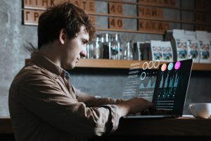 Homem busca em seu laptop com realidade aumentada as melhores ferramentas de tecnologia no rh