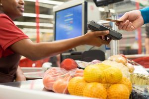 Pessoa realiza pagamento de compras em caixa de supermercado com vale-alimentação