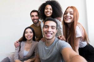 Cinco pessoas abraçadas sorrindo 