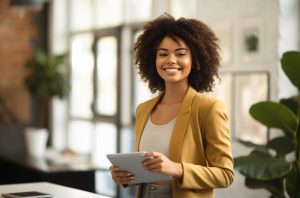 Mulher de negócios em pé olhando confiantemente para a câmera e sorrindo, representando a forma das mulheres no mercado de trabalho