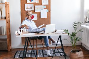 mulher sentada à mesa no home office