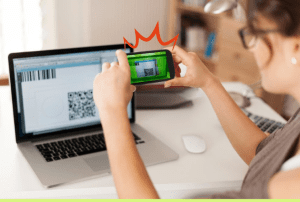 Pessoa faz pagamento via QR code na tela do computador usando celular